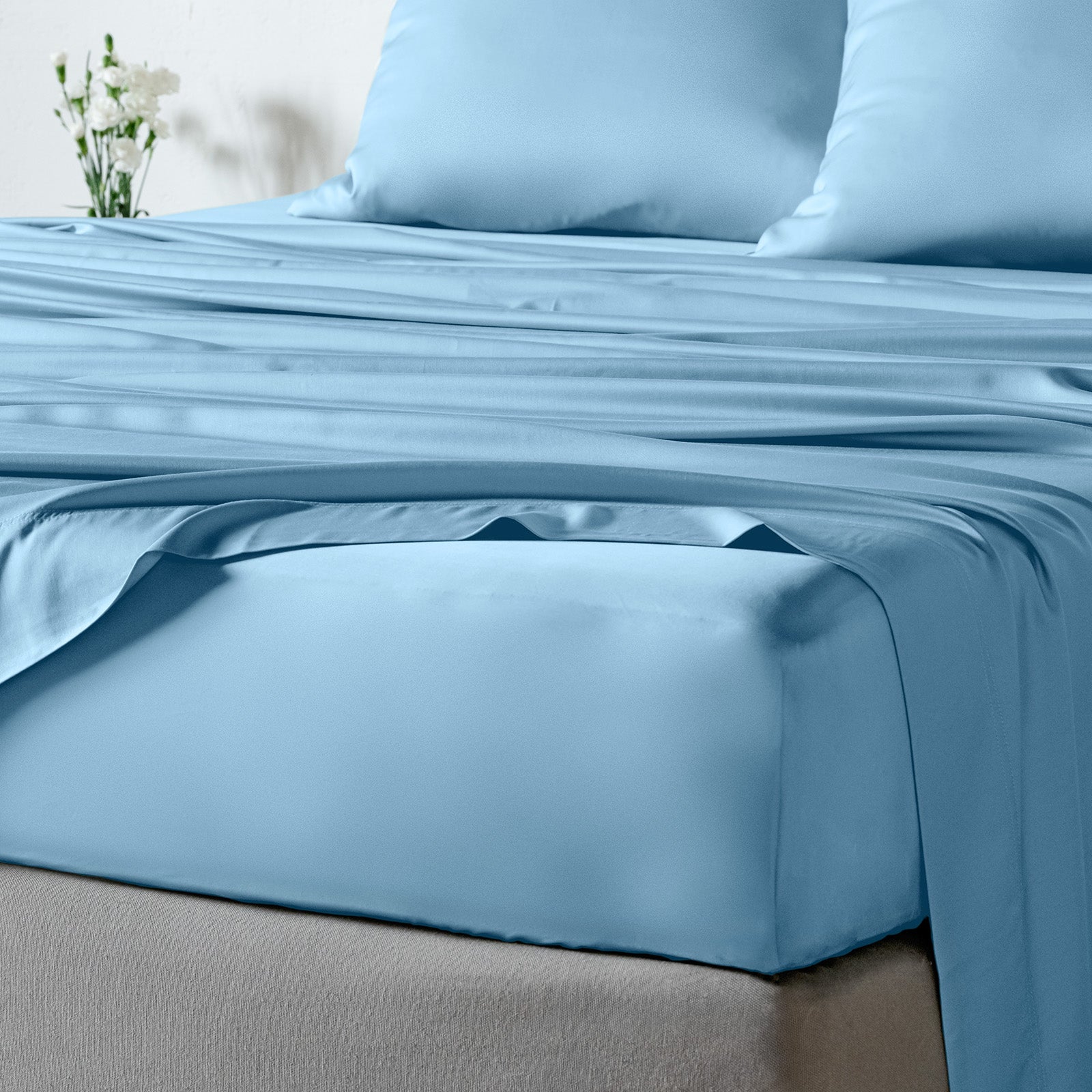 bambaw cozy bamboo bed sheets close up on a bed with fitted sheets and pillows in light blue colour
