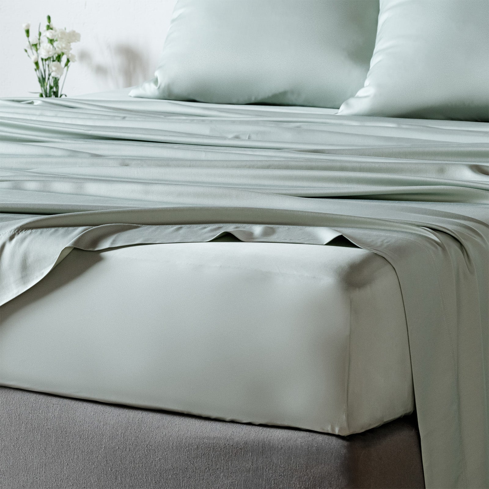 bambaw cozy bamboo bed sheets close up on a bed with fitted sheets and pillows in grey colour