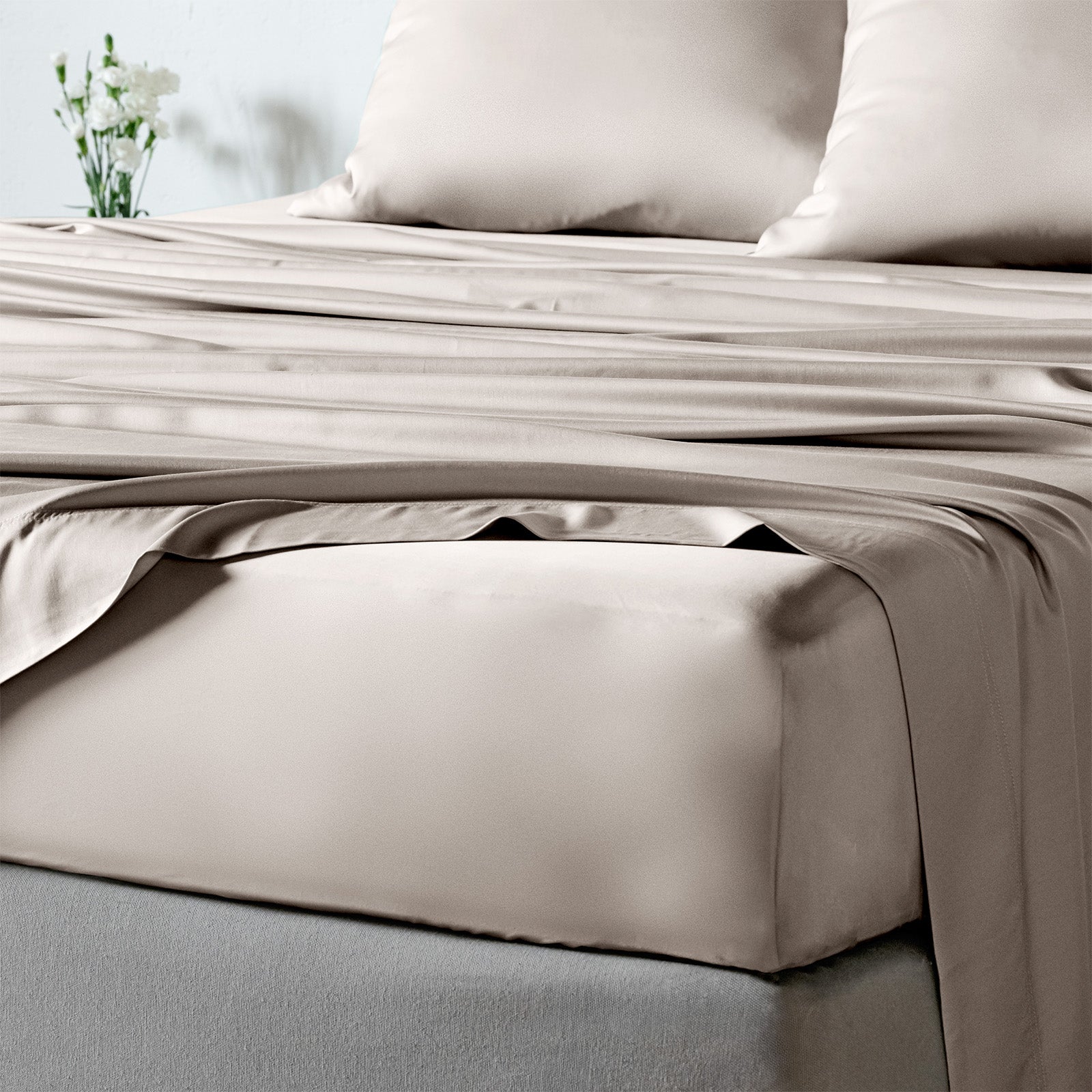 bambaw cozy bamboo bed sheets close up on a bed with fitted sheets and pillows in sand beige colour