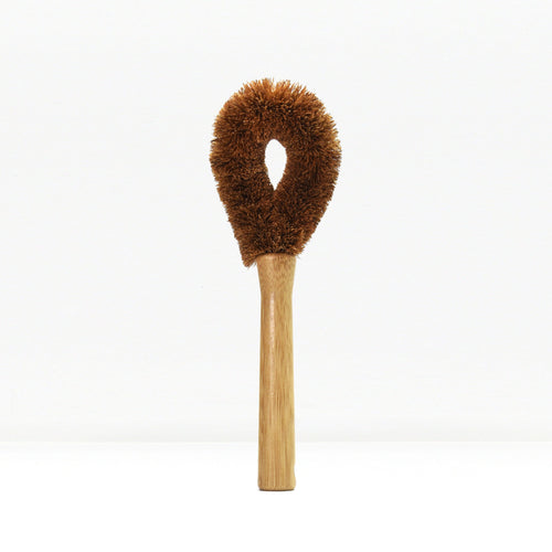 Brown fluffy dish brush with wooden handle on a white background